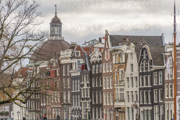 Typical Dutch house facades with gables and a church in the background, Amsterdam, Netherlands
