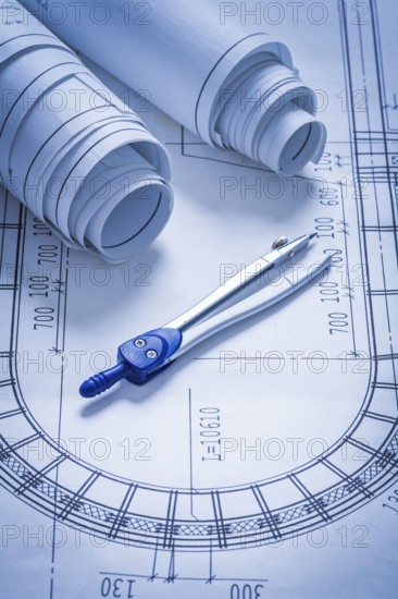 Blueprint rolls and pair of compasses construction concept