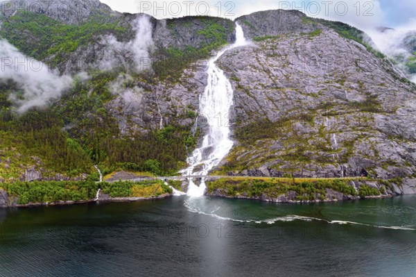 Langfossen cascade waterfall on the Vaule river. Western Norway. Passes through the highway. The photo was taken with a drone. Summer cold and rainy day