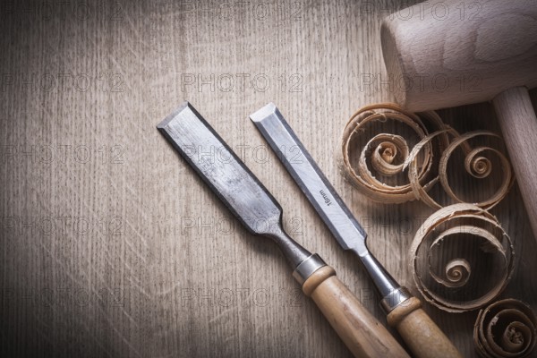 Planing chips wooden mallet carpenter??™s flat chisels on wood surface construction concept