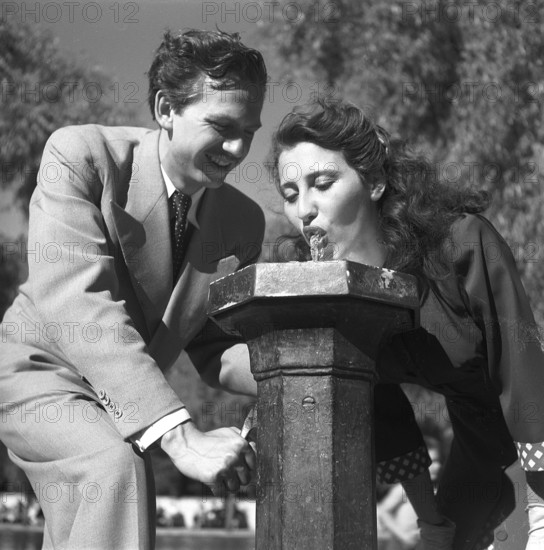 Summer in the 1940s. A girl drinks from a water fountain in one of Stockholms parks. These public fountains were common at this time and you operated it by pushing a lever down, and the water started to flow. Sweden July 1945 Kristoffersson ref O128-1