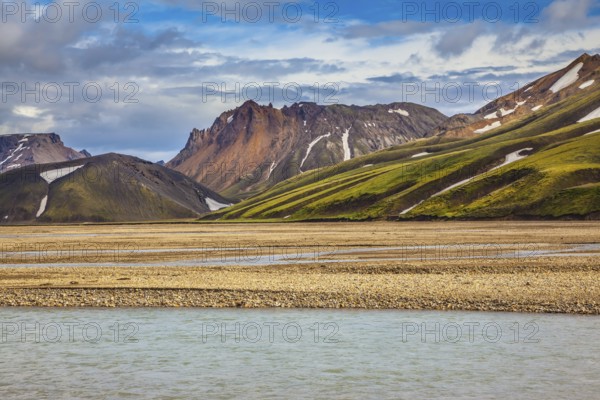 The magic of summer in Iceland. Cold water streams among yellow tundra. Landmannalaugar National Park