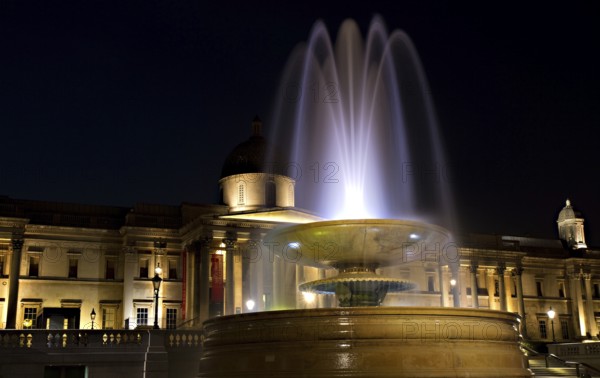 Illuminated Trafalgar Square with fountain and National Gallery, London, England London, England