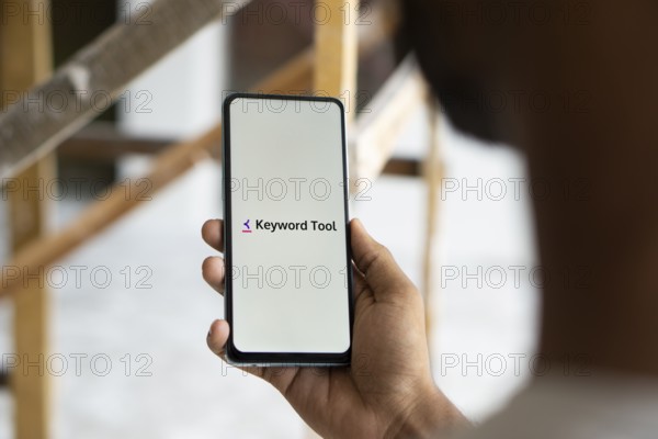 keyword tool logo is displayed on smartphone. Keyword Tool is a free online keyword research tool