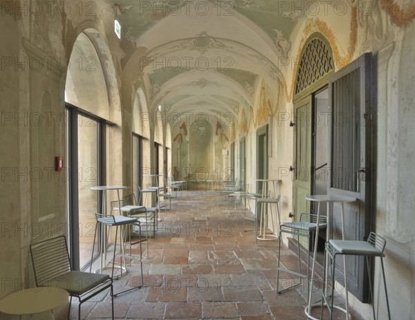 Modern bistro seating in a historic arcade with fresco paintings, successful combination of historic and modern, Raitenhaslach Monastery, Burghausen, Upper Bavaria, Bavaria, Germany, Europe
