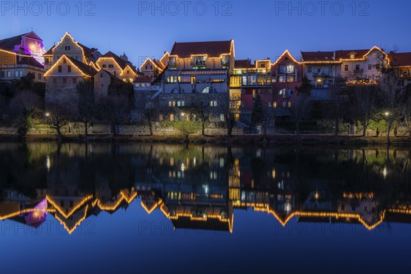Christmas illuminated house facade of Frohnleiten reflected in the river Mur, blue hour, Frohnleiten, Styria, Austria, Europe