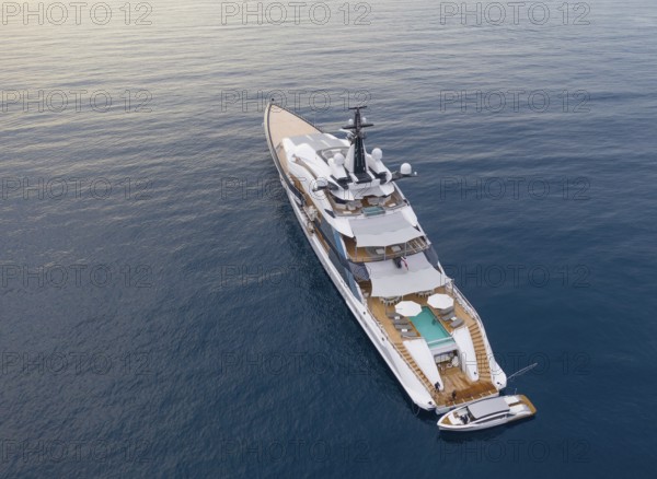 Aerial view of 109 metre motor yacht Bravo Eugenia, delivered in 2018 by the Dutch shipyard Oceanco to owner Jerry Jones, at anchor off the Principality of Monaco, behind Roquebrune Cap Martin, France, Cote d'Azur, Mediterranean Sea, Europe