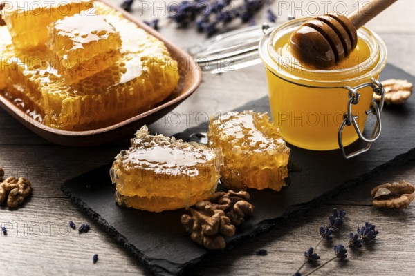 Honeycomb on slate tray with honey and nuts on kitchen table