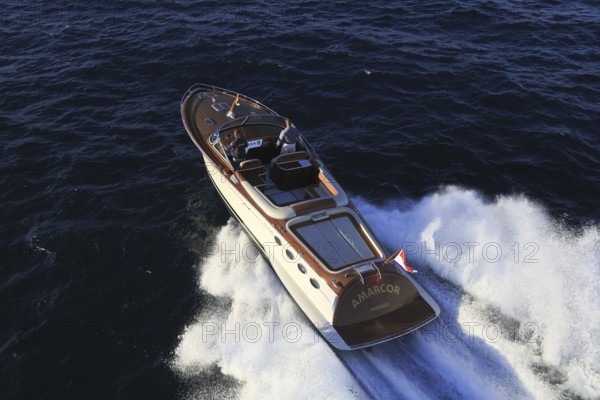Aerial view sports boat J Craft 42 Torpedo R at full speed on the Cote d'Azur, luxurious motorboat from the Swedish shipyard J Craft Boats with Volvo Penta engine in vintage style of the 50s and 60s in the style of the Riva boats, Mediterranean Sea