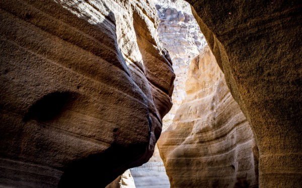 A narrow canyon with layered rock formations, illuminated by sunlight, creating dramatic shadows, Baranco de las Vacas, Gran Canaria, Canary Islands, Spain, Europe