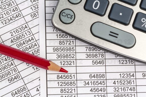 A calculator lies on the figures of a balance sheet and statistics. Symbol photo for turnover, profit and costs. Austria