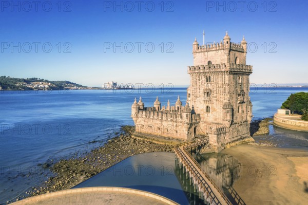 Drone shot of Belem tower landmark, Lisbon, Portugal at blue summer day sky. Medieval fortification on Tagus riverbank in late Gothic or Manueline style, UNESCO world heritage site, Age of Discoveries, tourist attraction, Portuguese seafaring history