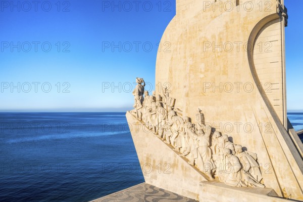 Monument to Discoveries or Padrao dos Descobrimentos to Age of Exploration shaped as ship with statues of Prince Henry the Navigator and great people of Portuguese seafarers history, Lisbon, Portugal, at clear blue sky on sunny day, Europe