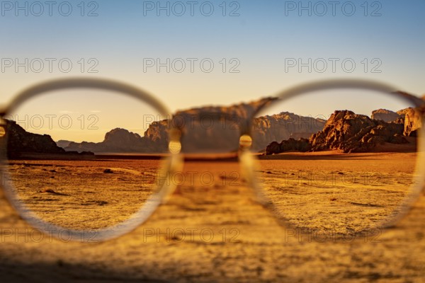 View at the Wadi Rum desert in Jordan through glasses during a nice sunset with clear sky. Travel, tourism and adventure
