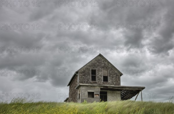 Abandoned Farm with storm clouds in the Canadian Prairie