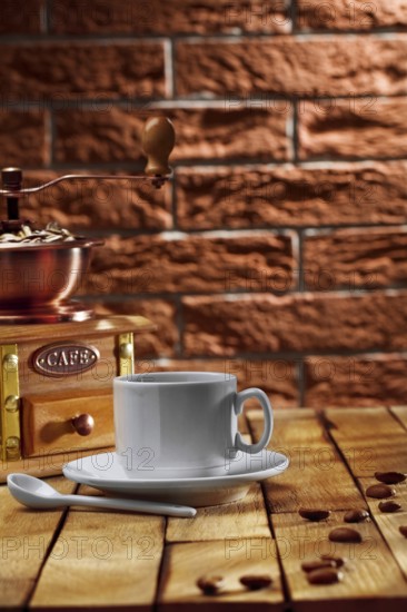 Coffee grinder and cup on table