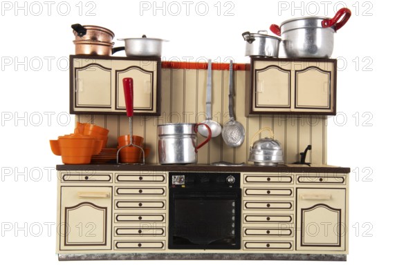 Miniature vintage toy kitchen with utensil isolated over white background