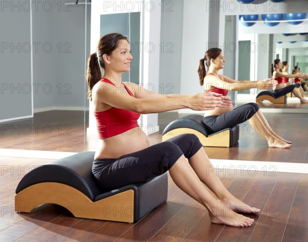 Pregnant woman pilates exercise with spine wave corrector