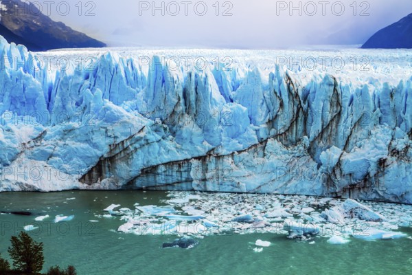 The colossal Glacier Perito Moreno in Patagonia on Lake Argentino. The cloudy sky covers the horizon. The concept of active and ecological tourism