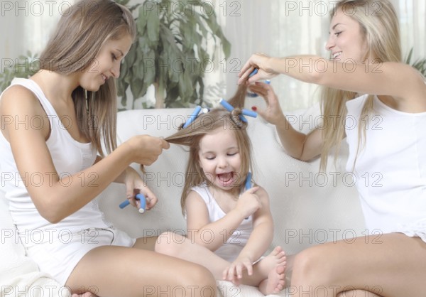 Three girls having fun together of maiking hair
