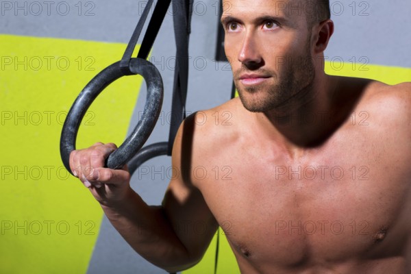 Crossfit dip ring man relaxed after workout at gym dipping exercise