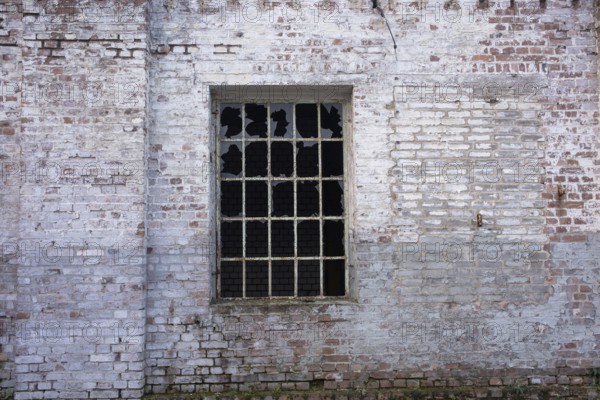 An old, weathered brick wall with a broken window, evoking a rustic atmosphere