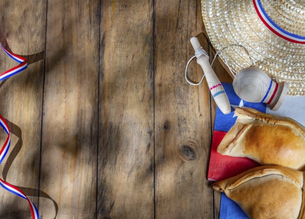 Food, Chilean independence day concept. fiestas patrias. Tipical baked empanadas, wine or chicha, fat and play emboque. Decoration for 18 september party day, wooden background, top view