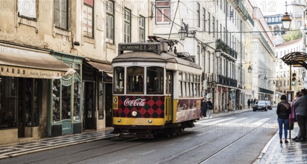 Lisbon, Portugal, 12 28 2018: Typical tramway driving in downtown Bairro Chiado in the steep narrow shoppingstreets, Europe