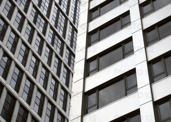Close up detail of tall high rose modern apartment buildings with white cladding and dark windows