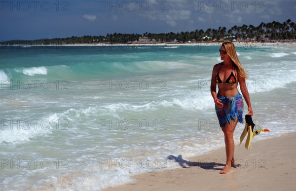 Woman strolling on a sandy beach, Catalina Island, Caribbean, Dominican Republic, Central America