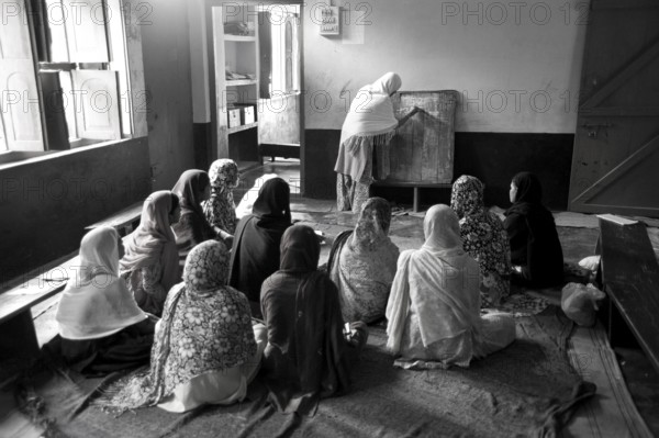 Muslim teacher with children in classroom Islamic school uttar pradesh India Asia