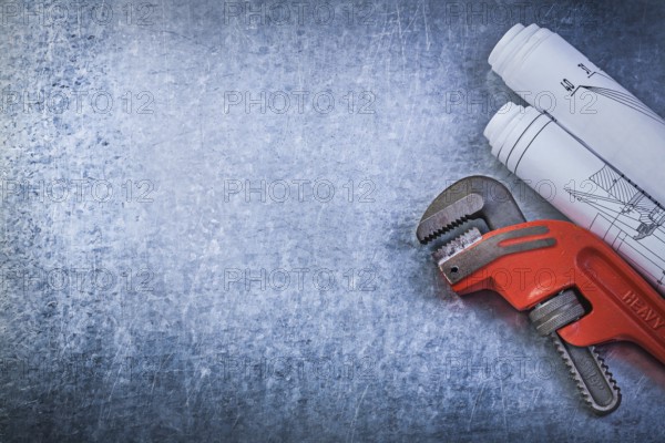 Monkey wrench construction plans on metallic background plumbing concept