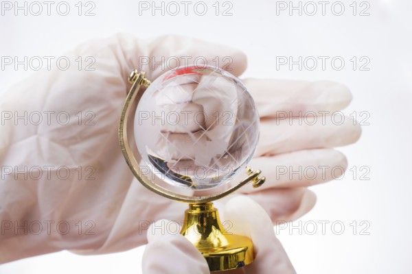 The pandemic concept. Hands in white gloves holding a globe
