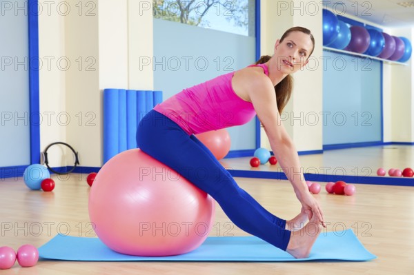 Pilates woman fitball swiss ball exercise workout at gym indoor