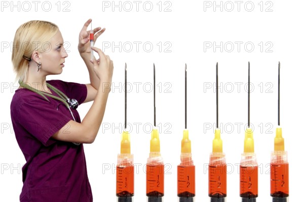 A beautiful blonde woman medical doctor preparing an injection in a syringe