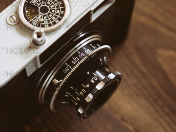 Close up photo of old vintage camera lens over wooden table. selective focus