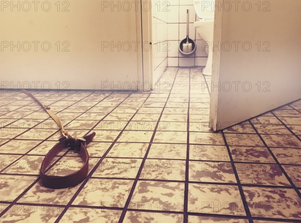 Dog leash on floor under door of toilet surrealistic image amsterdam