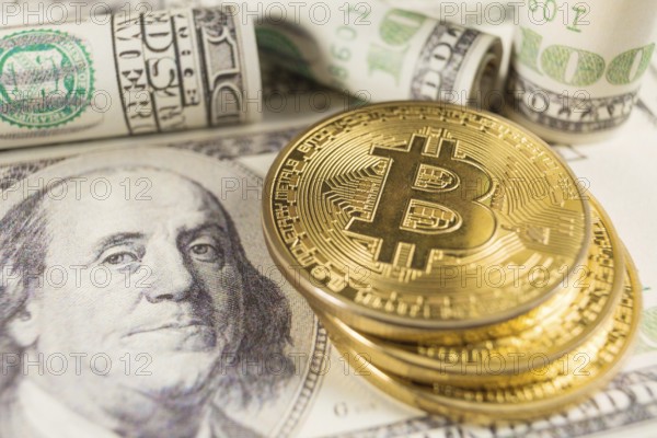 Bitcoin stack and banknotes of one hundred dollar. Conceptual image for global cryptocurrency blockchain payment system