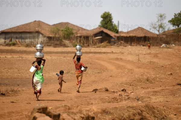 Women carrying pots of water from well at Mal village, Thane, Maharashtra, India, Asia
