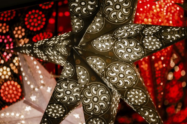 Decorative, illuminated stars with an artistic pattern create a warm, Christmassy atmosphere at a Christmas market, Cologne, North Rhine-Westphalia, Germany, Europe