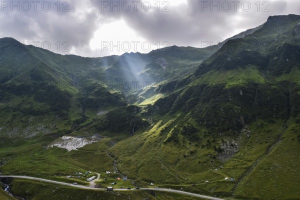 View over the Transfagarasan mountains and the tortuous road with sun rays through the clouds