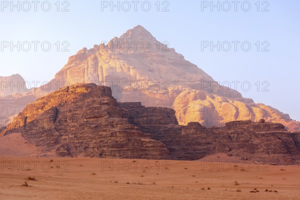 Wadi Rum, Jordan. The orange sand desert landscape and Jabal Al Qattar mountains at dawn, sunset