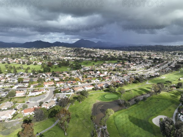 Aerial view of residential neighborhood surrounded by golf and valley during cloudy day in Rancho Bernardo, San Diego County, California. USA