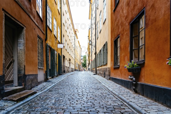 Beautiful old cobblestoned street amidst old colorful houses in Gamla Stan Quarter in Stockholm