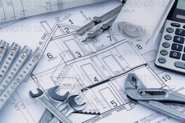 An architect's construction plan with a calculator. Symbolic photo for financing and planning a new house. Austria