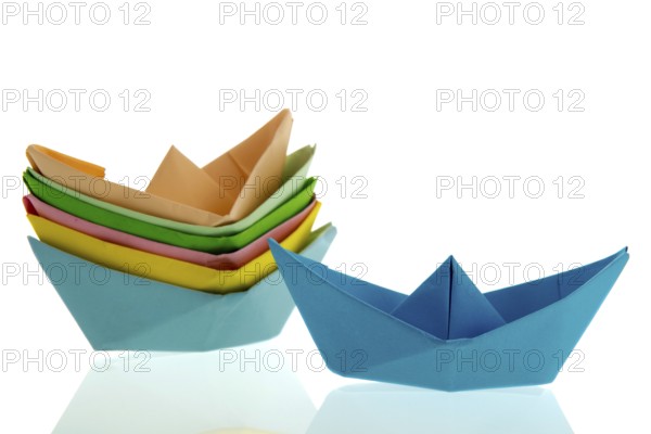 Colorful folded paper boats isolated over white background