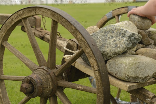Stones are loaded onto an old wooden cart - close-up