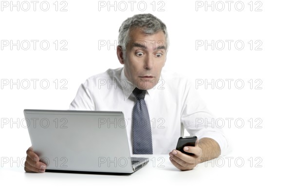 Surprised senior businessman expression gesture mobile phone laptop gray hair