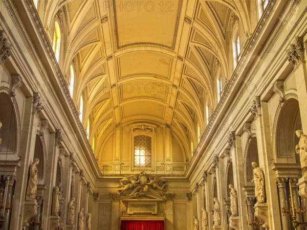 Brightly lit nave of a baroque church, decorated with high ceilings and long rows of columns, montserrat, spain