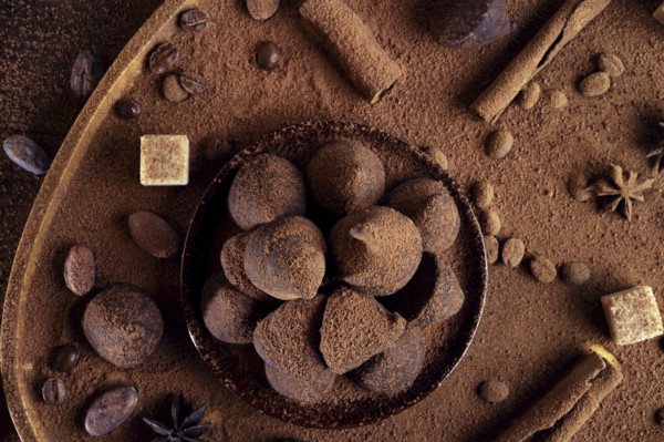 Healthy delicious chocolate truffles around ingridients with natural cocoa beans, powder, cacao butter, cane sugar. healthy sweets concept. close up. flat lay